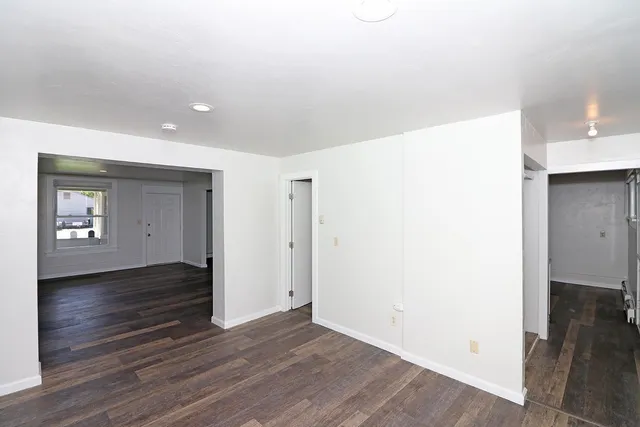 a view of an empty room with wooden floor and closet
