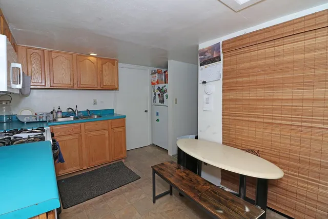 a room with stainless steel appliances furniture a rug and a window