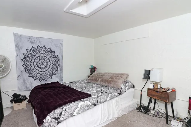 a bedroom with a bed and a chair in it