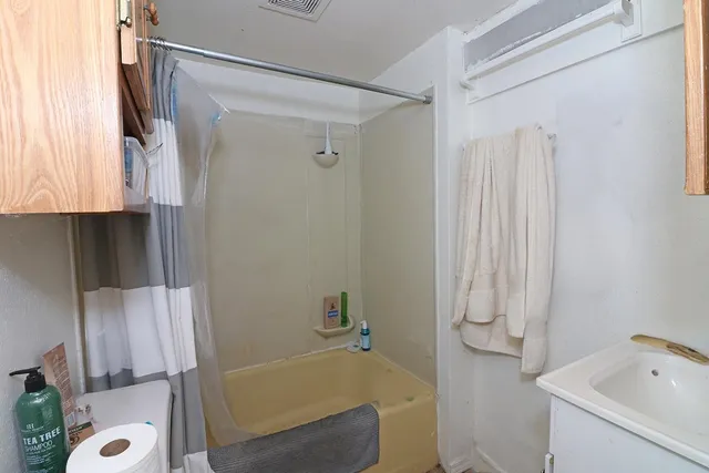 a bathroom with a tub a sink and a shower