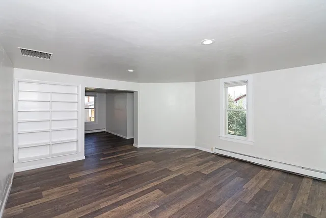 wooden floor in an empty room with a window