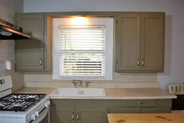 a kitchen with a sink cabinets and a window