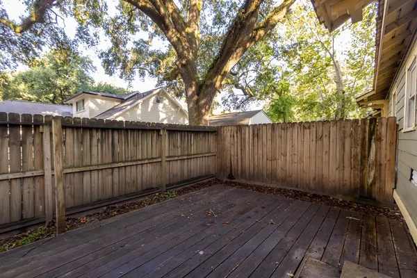 a view of deck with wooden floor and large trees
