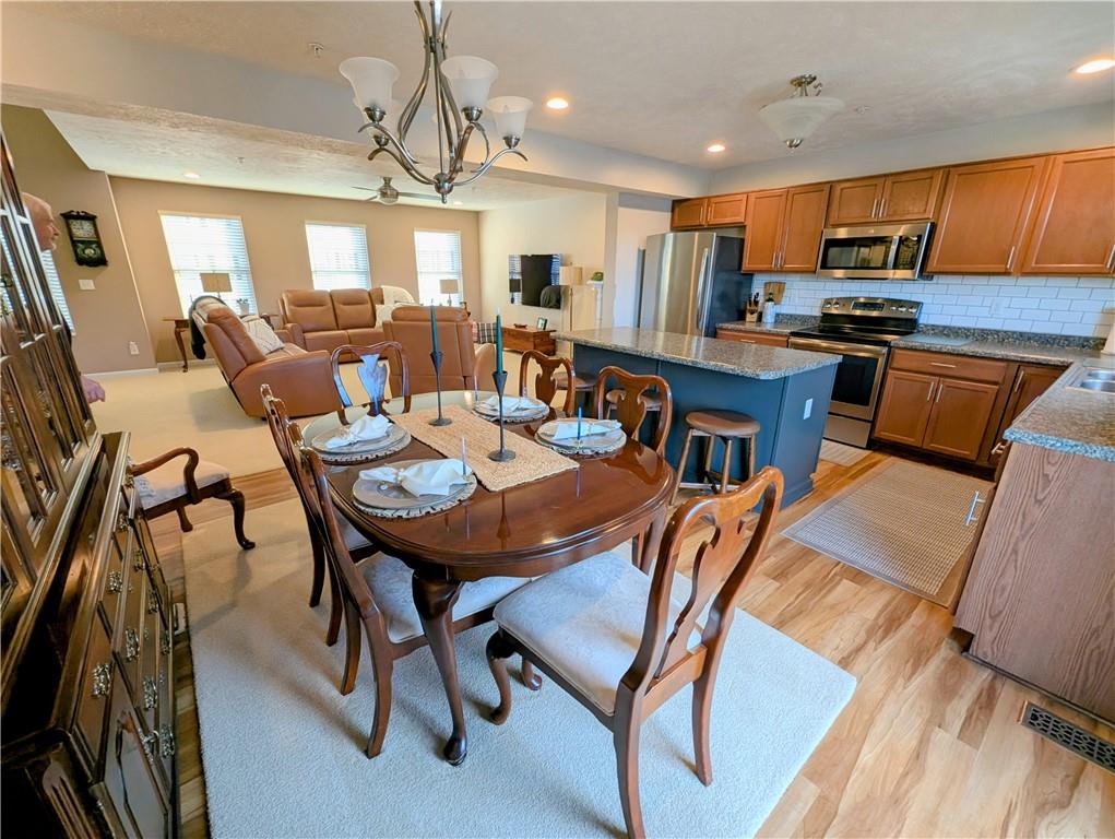 146 Rylie Drive Harmony, PA 16037 - Photo 16 of 43 a open dining room with stainless steel appliances kitchen island granite countertop a table chairs and a refrigerator