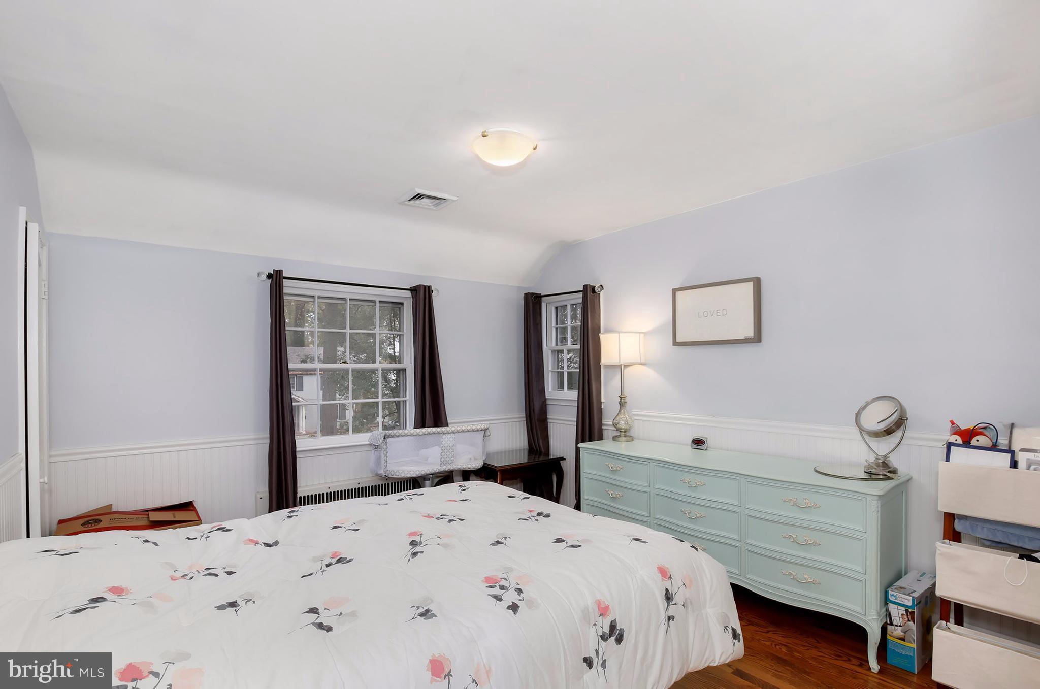 603 Carysbrook Road Baltimore, MD 21208 - Photo 21 of 30 a bedroom with a bed and wooden floor