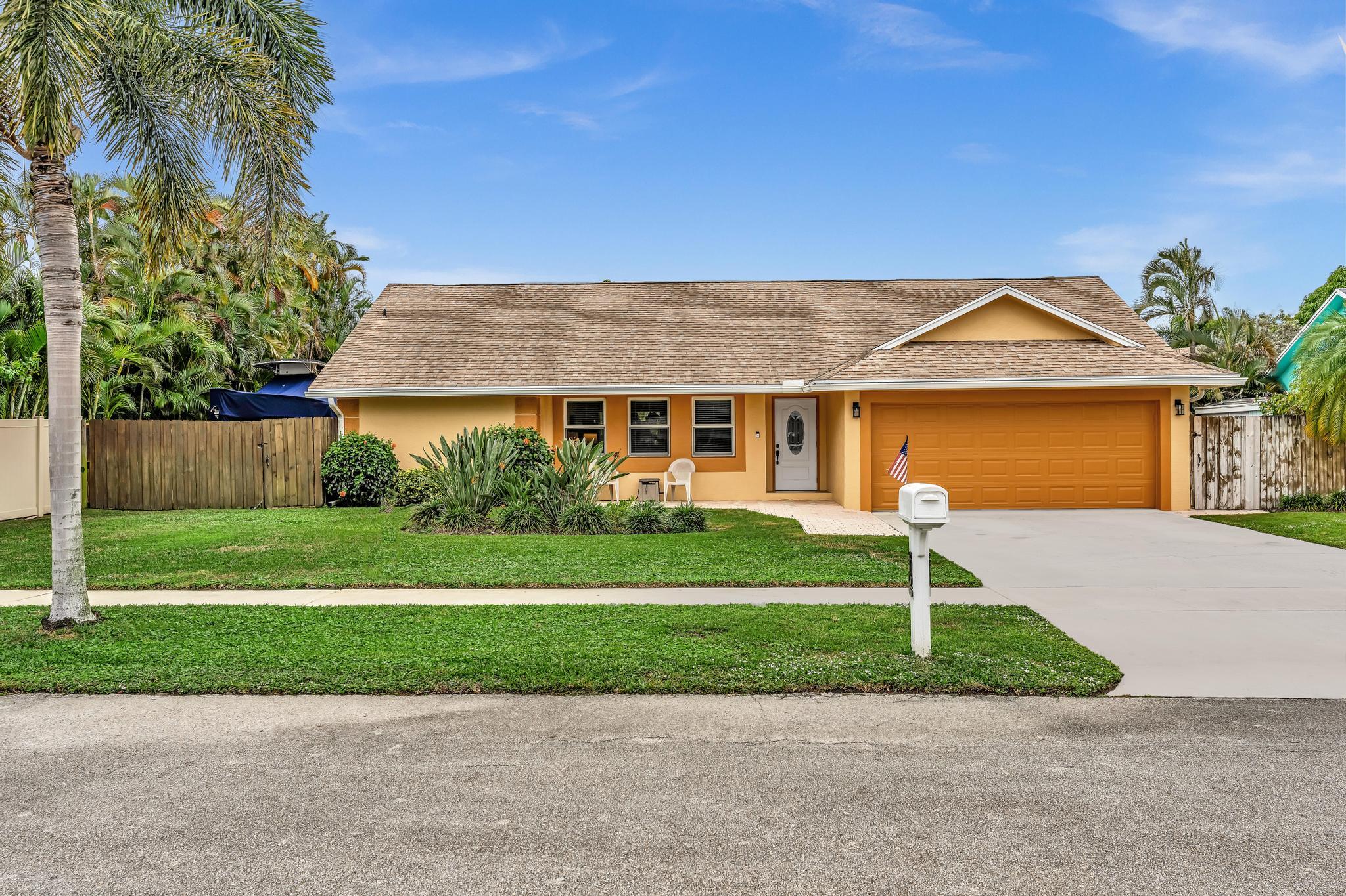 3106 Cormorant Road Delray Beach, FL 33444 - Photo 27 of 45 a front view of a house with a yard and garage