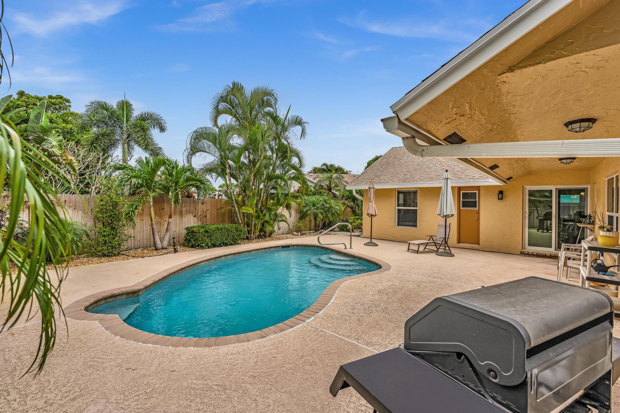 3106 Cormorant Road Delray Beach, FL 33444 - Photo 31 of 45 a swimming pool with outdoor seating and yard