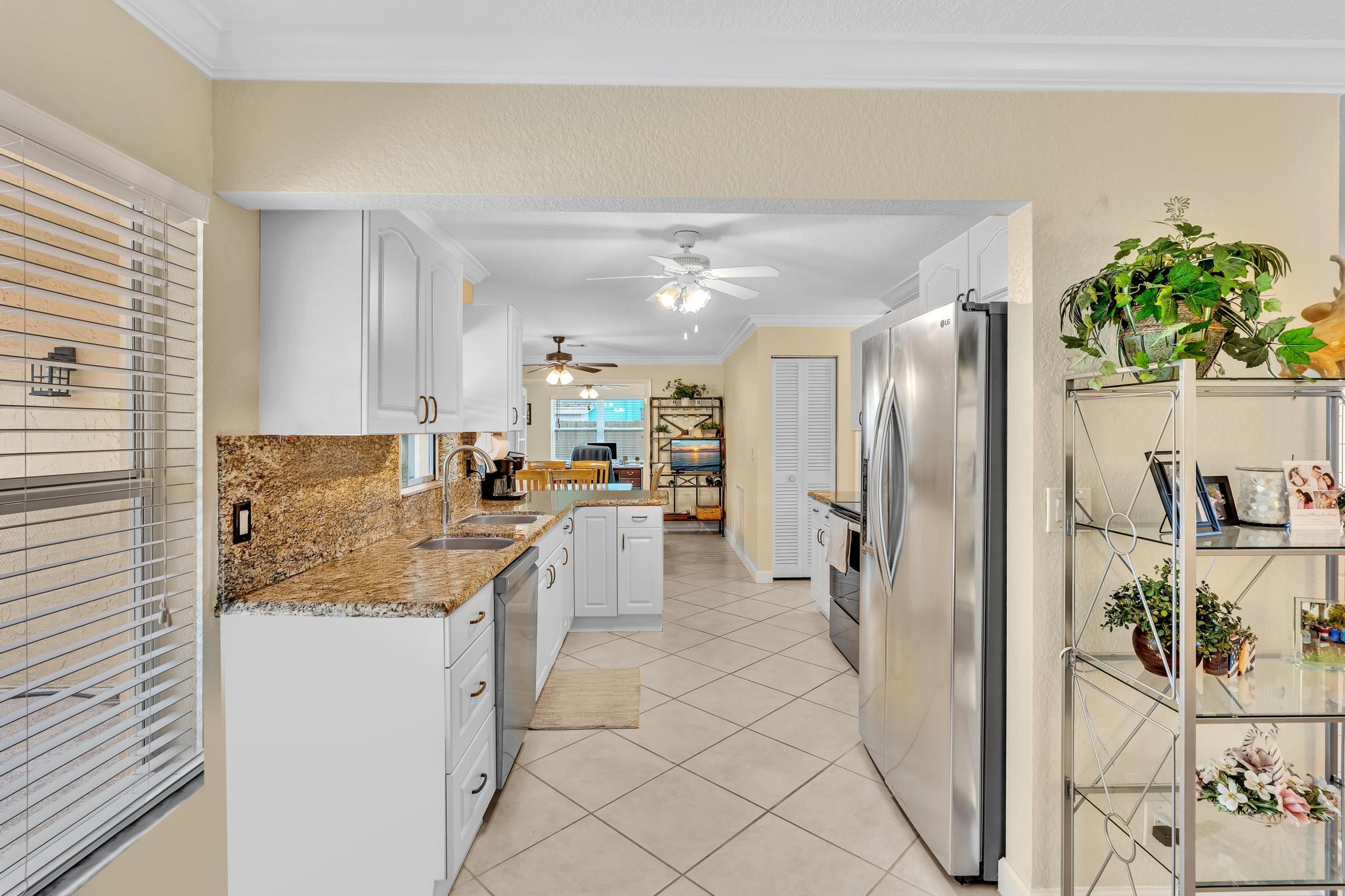 3106 Cormorant Road Delray Beach, FL 33444 - Photo 9 of 45 a kitchen with stainless steel appliances granite countertop a refrigerator and a sink