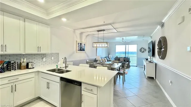 a kitchen with a sink a stove cabinets and living room view