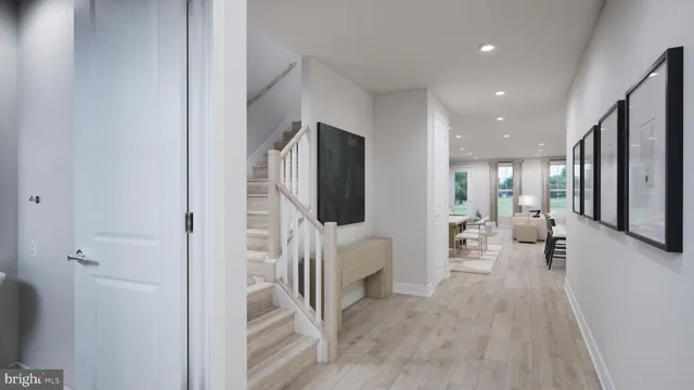 a hallway with white cabinets and couches with wooden floor