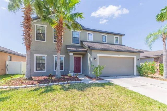 a front view of a house with a yard and garage