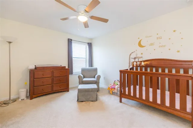 a bedroom with a large bed chandelier and a window