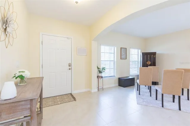 a living room with furniture a dining table and a potted plant