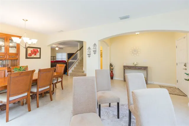 a dining room with furniture a flat screen tv and a chandelier