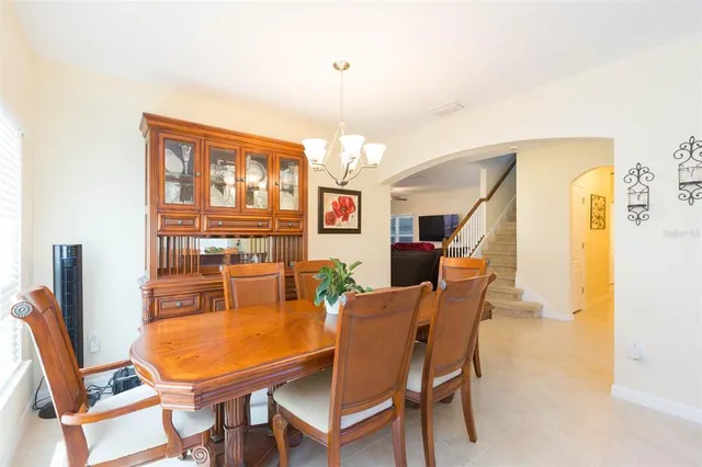 a view of a dining room and livingroom with furniture wooden floor a chandelier