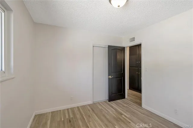 a view of an empty room with closet and a window