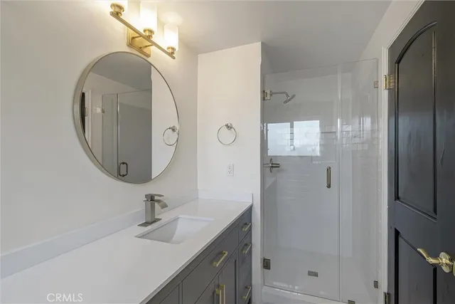 a bathroom with a sink mirror and shower