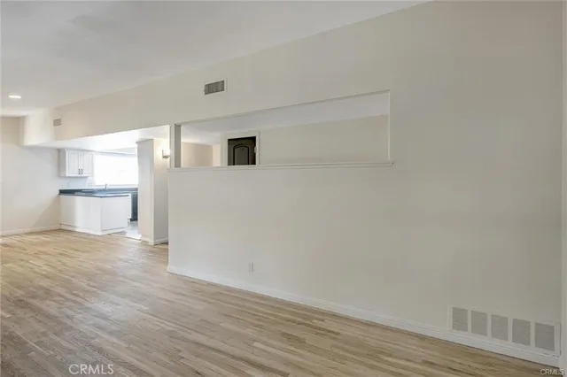 a view of a kitchen with wooden floor and a refrigerator