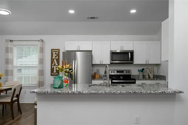 a kitchen with refrigerator and chairs