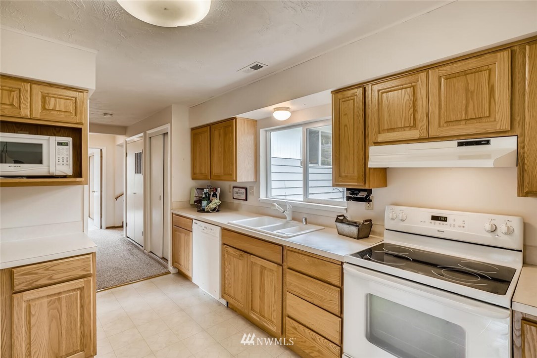 23915 Brier Road Brier, WA 98036 - Photo 13 of 39 a kitchen with stainless steel appliances granite countertop a stove a sink and a refrigerator