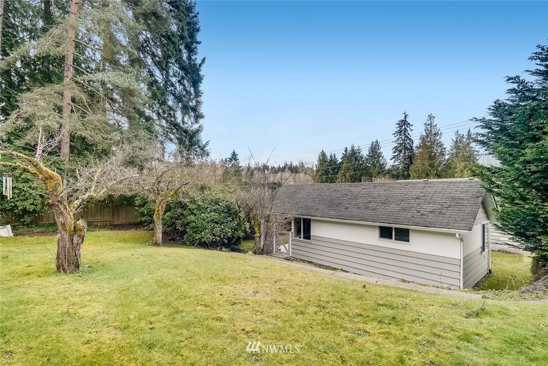 23915 Brier Road Brier, WA 98036 - Photo 35 of 39 a backyard of a house with large trees and wooden fence