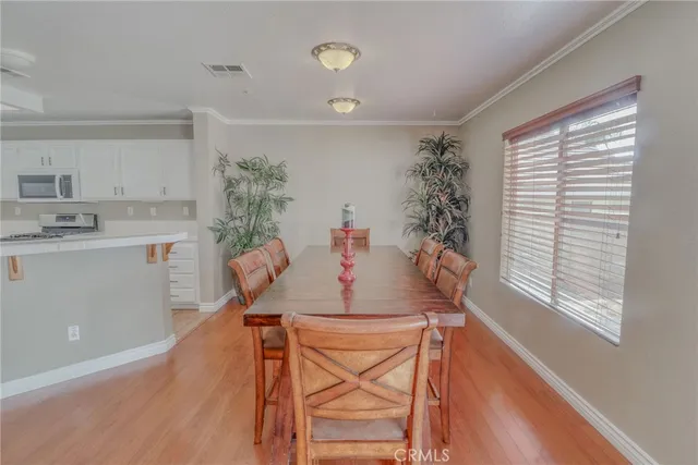 a living room with furniture and a dining table with wooden floor
