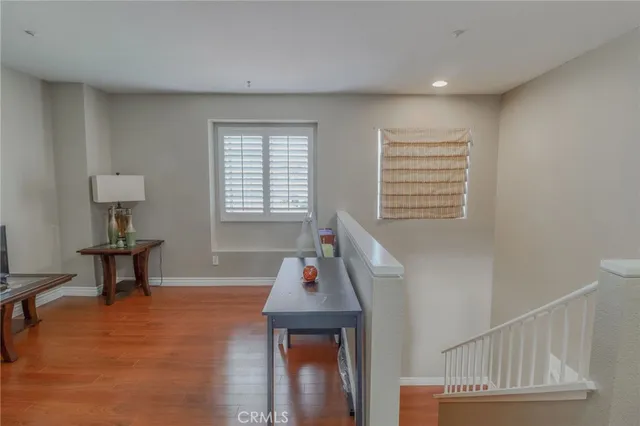 a view of a hallway with wooden floor and staircase