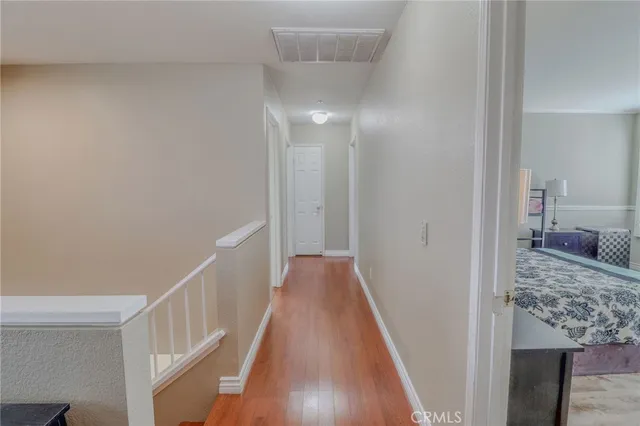 a spacious bedroom with a bed and wooden floor