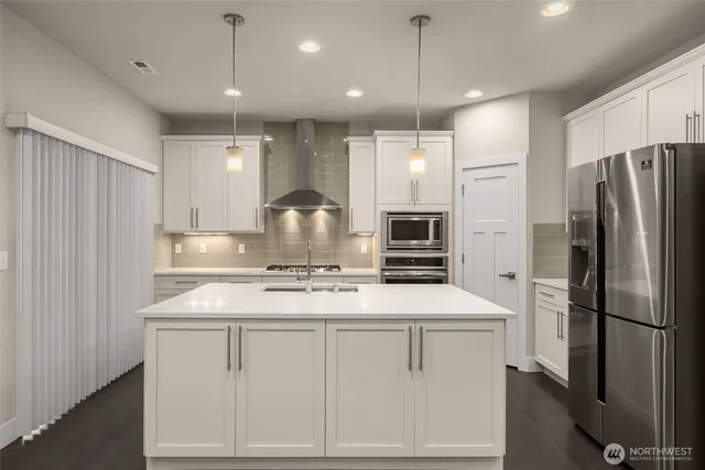 a kitchen with white cabinets and stainless steel appliances