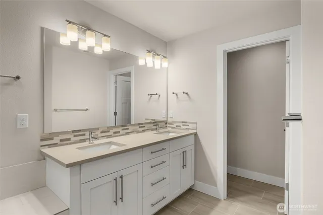a bathroom with a granite countertop sink a large mirror and a bathtub