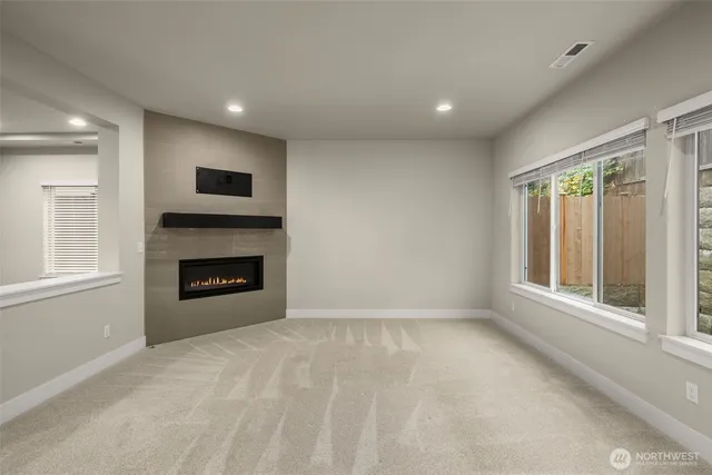 a view of a livingroom with kitchen and fireplace