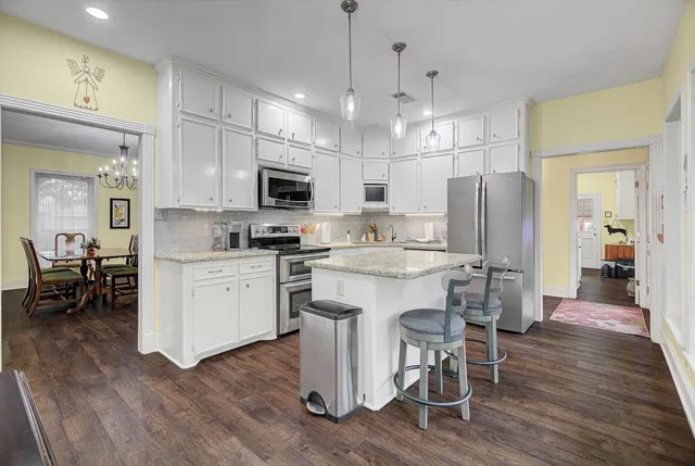 a kitchen with a refrigerator a sink and a stove top oven