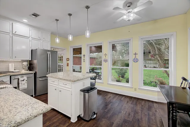 a kitchen with a table chairs refrigerator and cabinets