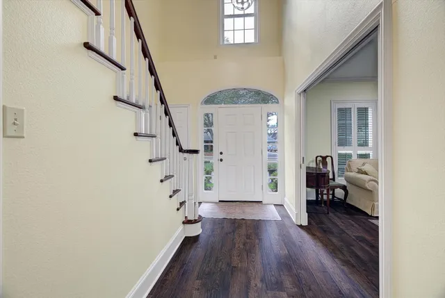 a view of a hallway with wooden floor and staircase