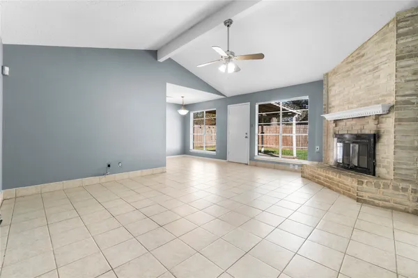 a view of an empty room with a fireplace and a window