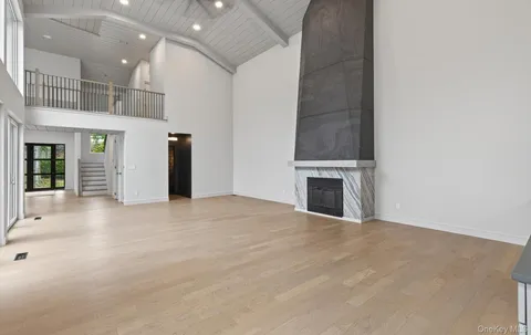 an empty room with kitchen and fireplace