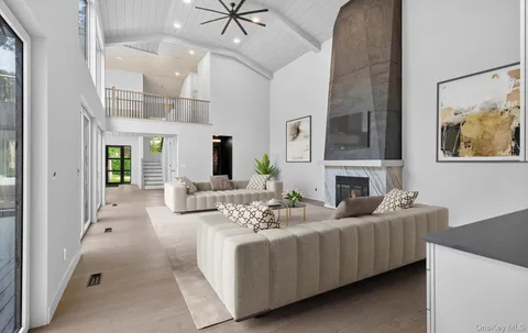 a living room with furniture a fireplace and a chandelier