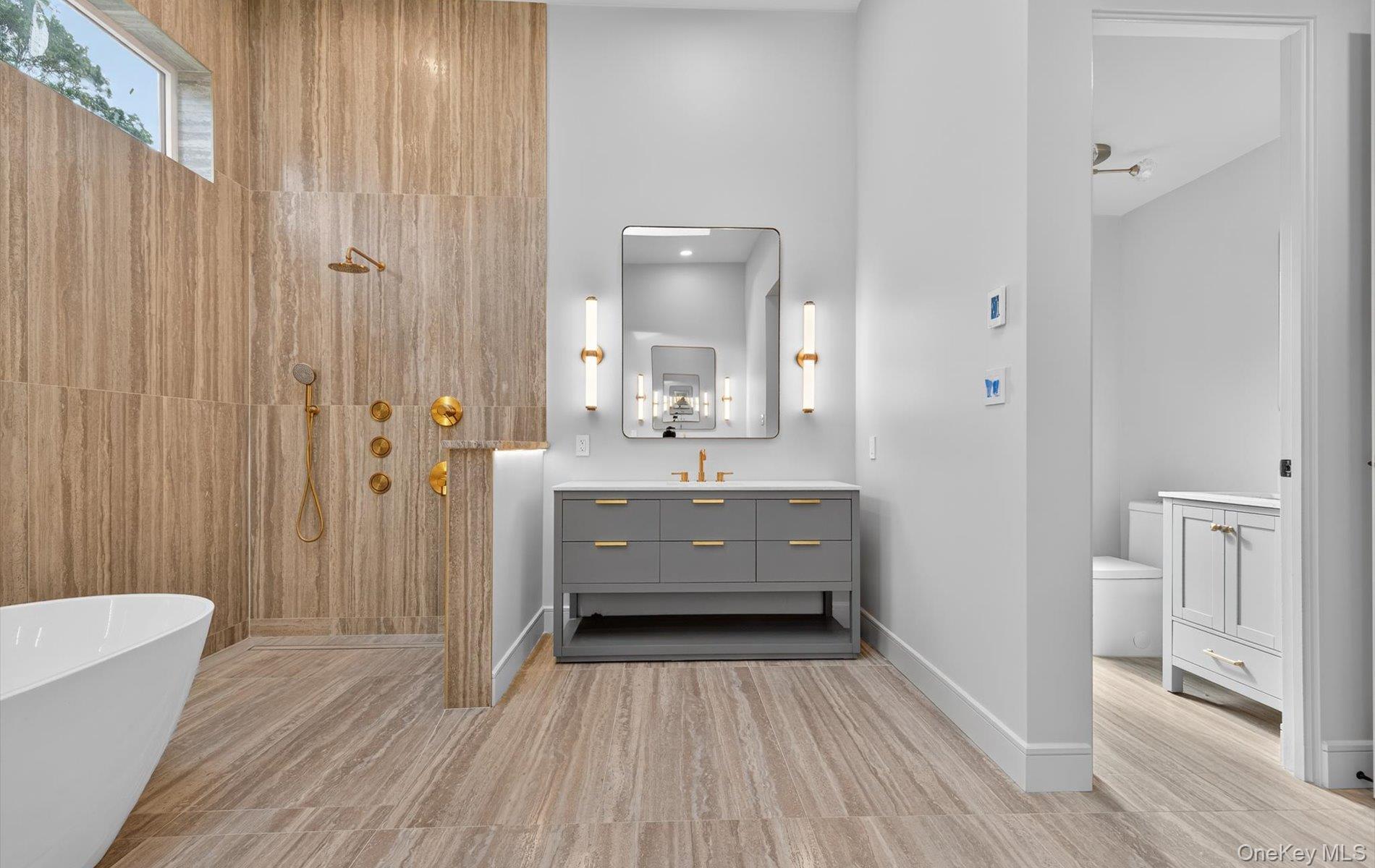 26 Windemere Way Woodbury, NY 11797 - Photo 22 of 40 a bathroom with a sink a mirror and a bathtub