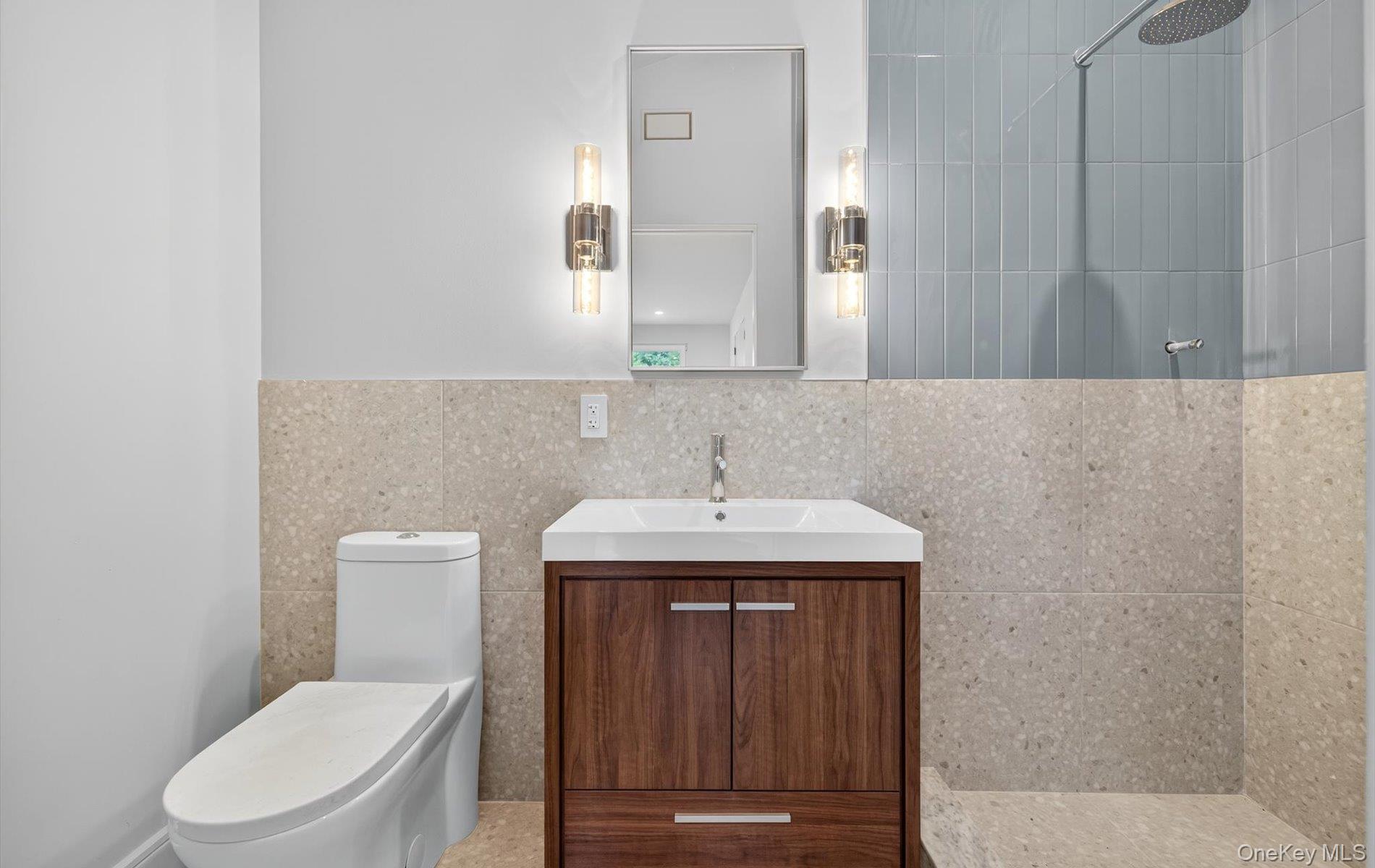 26 Windemere Way Woodbury, NY 11797 - Photo 25 of 40 a bathroom with a toilet a sink and mirror