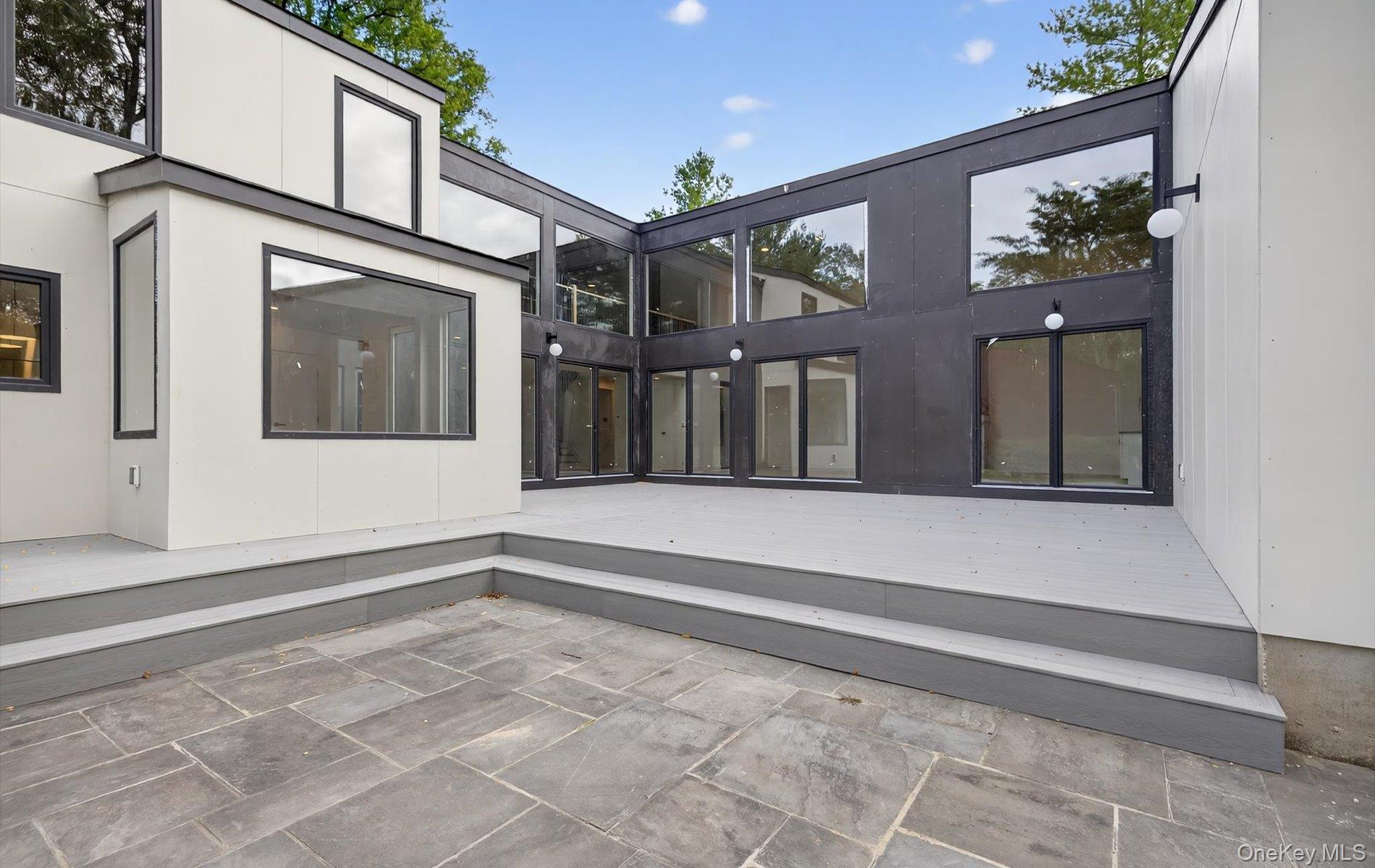 26 Windemere Way Woodbury, NY 11797 - Photo 31 of 40 a view of a house with a large windows and plants