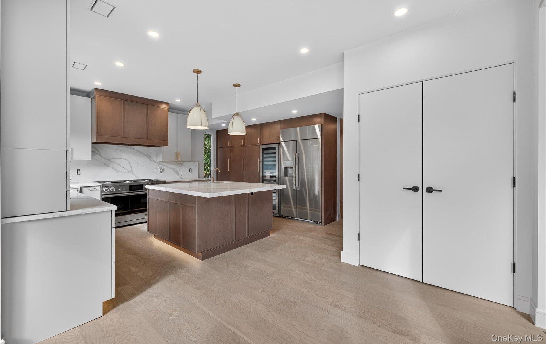 26 Windemere Way Woodbury, NY 11797 - Photo 8 of 40 a kitchen with stainless steel appliances granite countertop a refrigerator and a sink