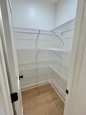 a view of walk in closet with empty racks