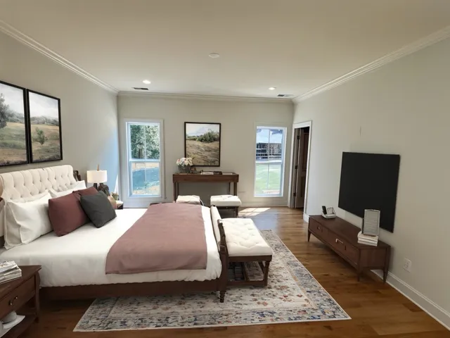 a bedroom with a bed flat screen tv and window