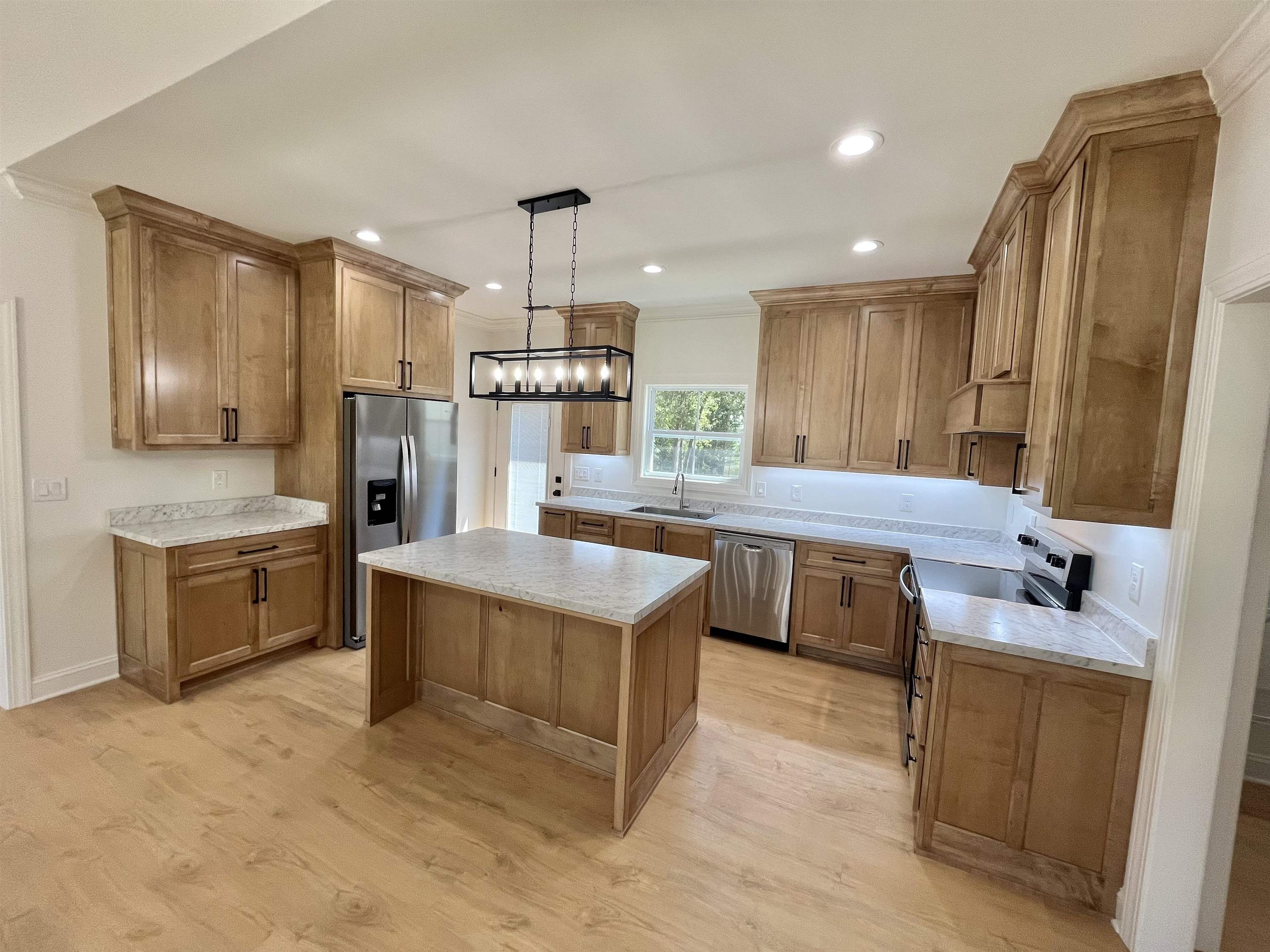 135 Paine Road Savannah, TN 38372 - Photo 7 of 14 a kitchen with kitchen island granite countertop a sink refrigerator stove and microwave