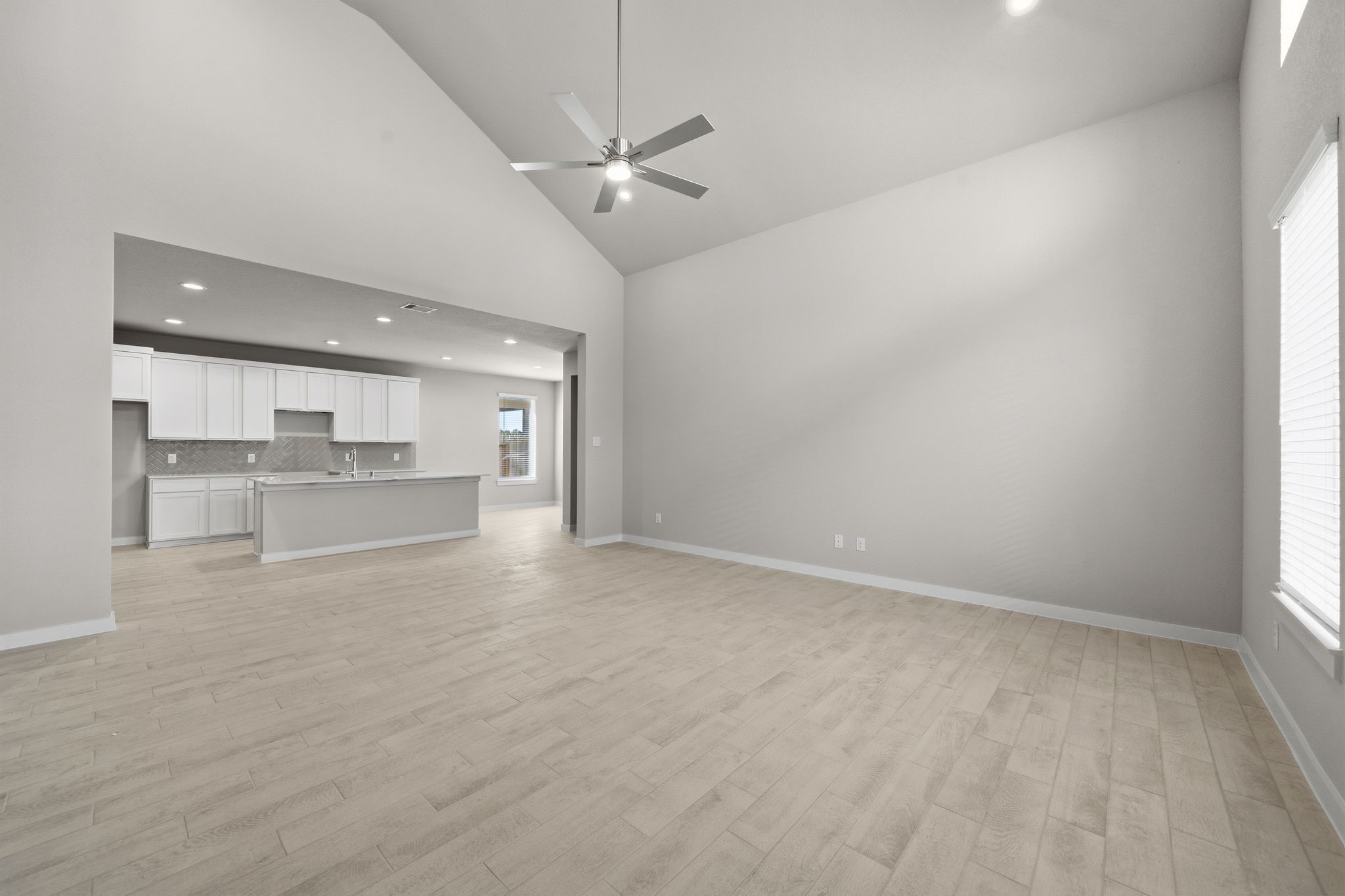 2567 Forest Cedar Lane Conroe, TX 77301 - Photo 14 of 40 an empty room with wooden floor kitchen view and a window