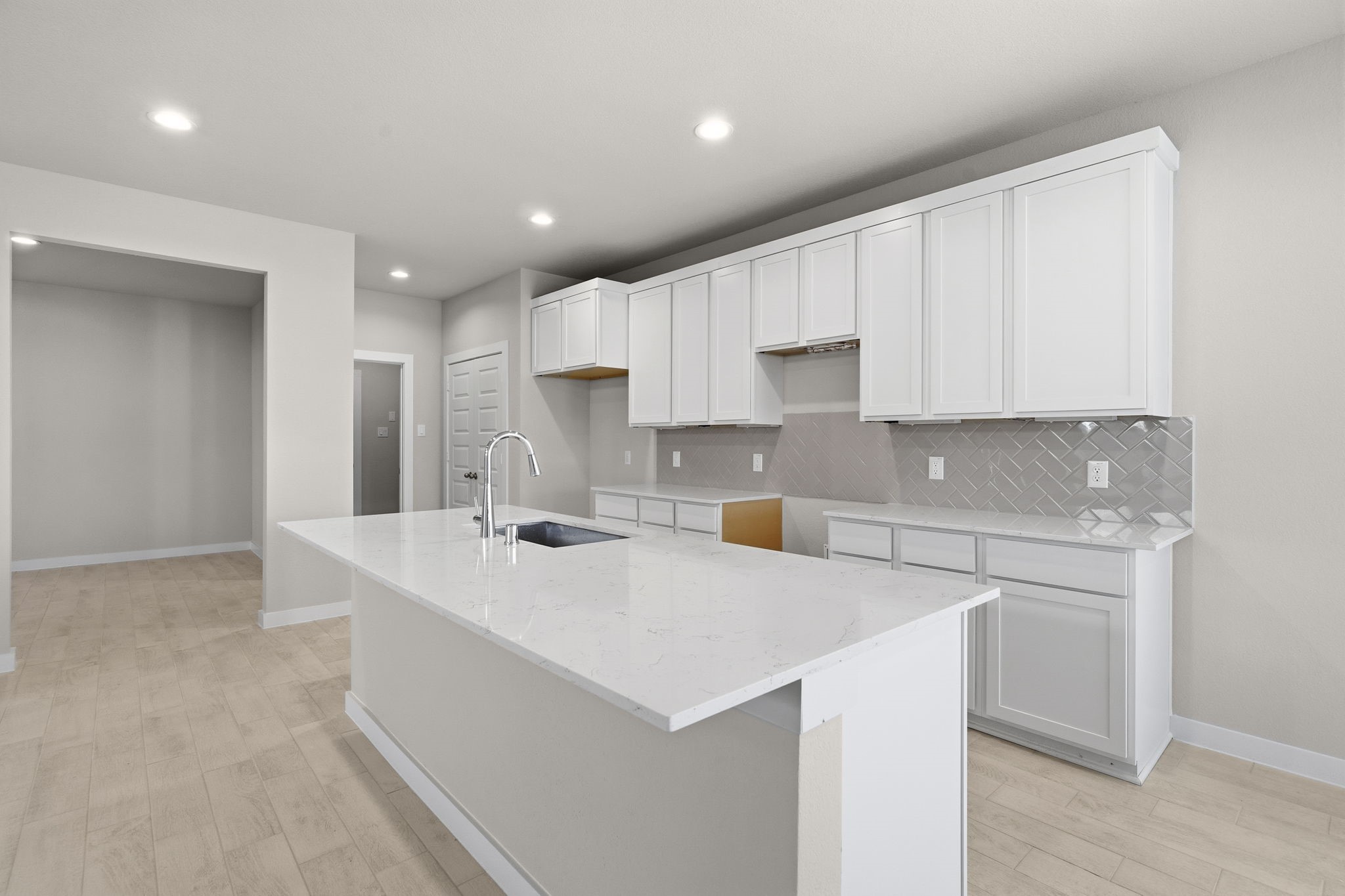 2567 Forest Cedar Lane Conroe, TX 77301 - Photo 3 of 40 a kitchen with a sink a stove a refrigerator and white cabinets