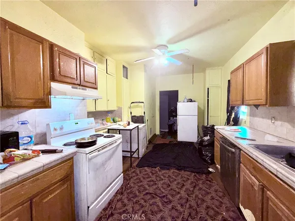 a kitchen with stainless steel appliances a sink stove refrigerator and cabinets