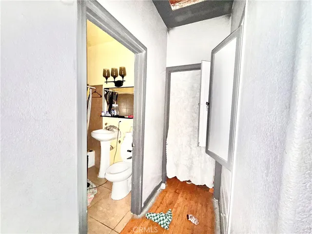 a view of a hallway with wooden floor and a dining room