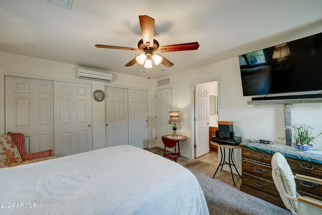 a bedroom with a bed and a flat screen tv