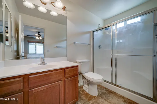 a bathroom with a sink a toilet a mirror and shower